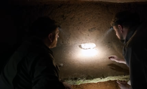 Archaeologists examine Etruscan skeletons and bronze artifacts inside a monumental burial chamber.